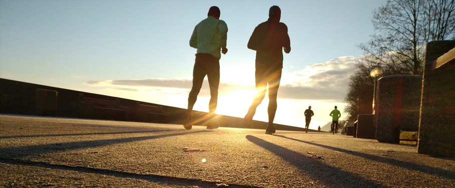 Runners pound along the pavement in bracing winter sunshine.